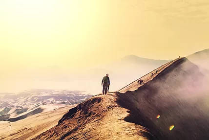 Man walking on a path on a the crest of a mountain