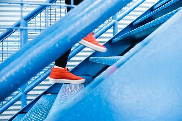 View of feet taking steps on stairs