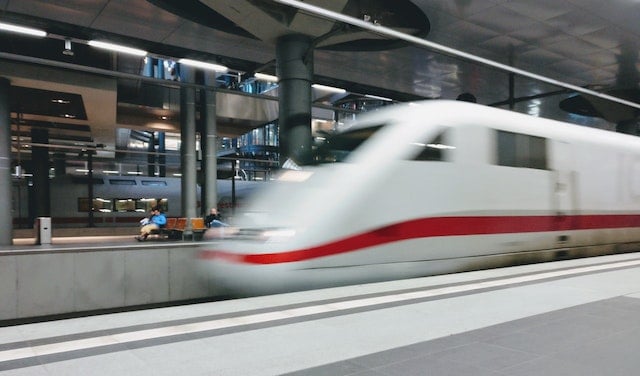 A blurred image of a very fast, modern train speeding though railway station.